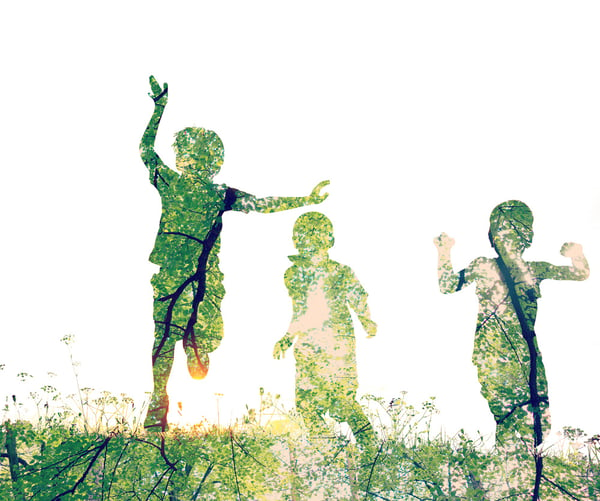 Children running on meadow at sunset