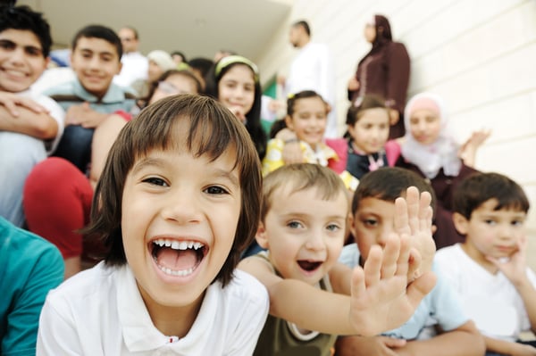 Crowd of children, different ages and races in front of the school, breaktime