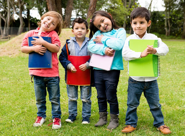 Happy group of school kids holding notebooks outdoors-1