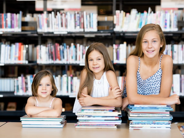 Little girls reading books in library