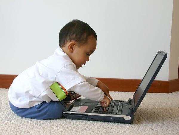 little boy playing with a laptop